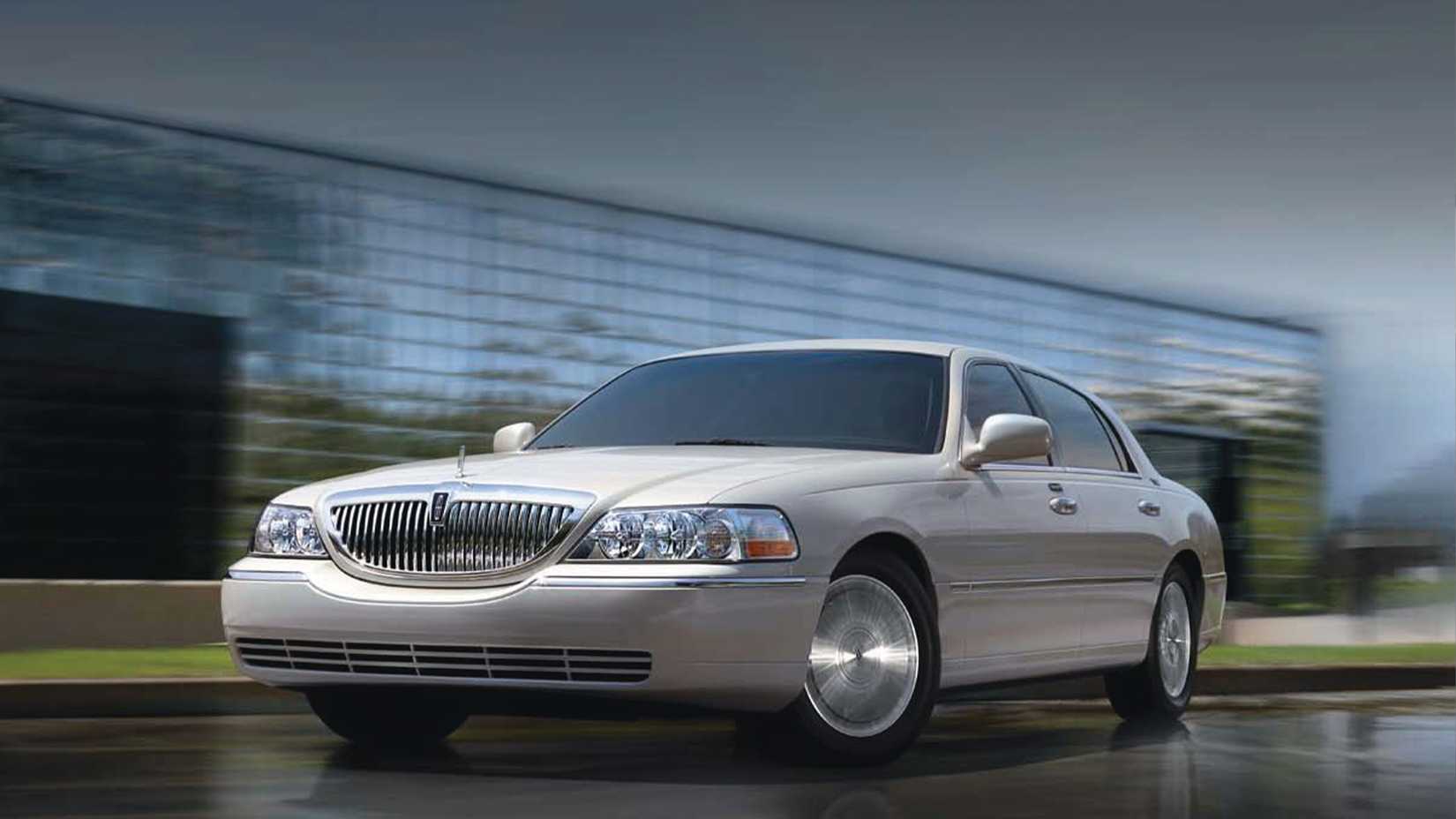 silver 2011 Lincoln Town Car parked on wet tarmac