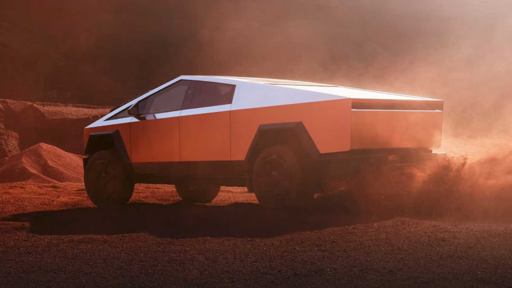 2024 Tesla Cybertruck Rear Angled View Sand Driving