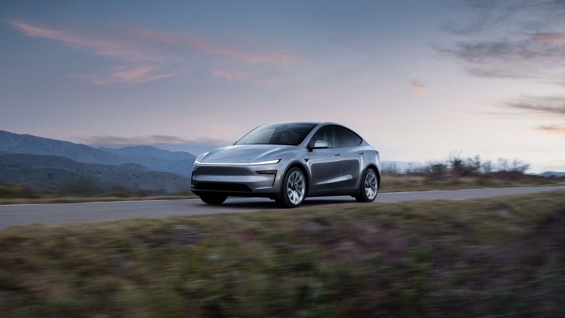 2025 Tesla Model Y Silver Front Angled View Driving