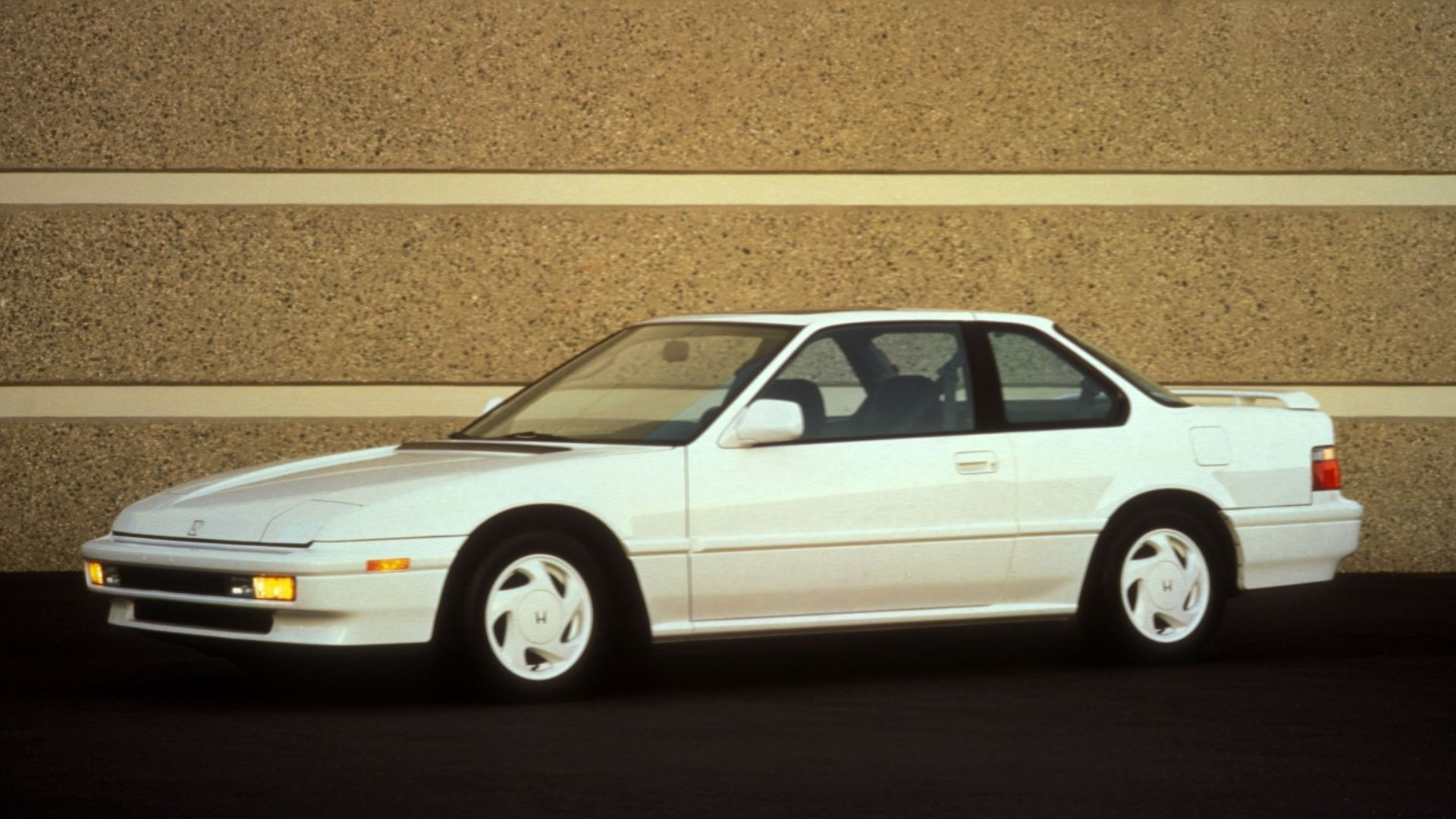 vintage photo of a white 1991 Honda Prelude Si parked against a brick wall