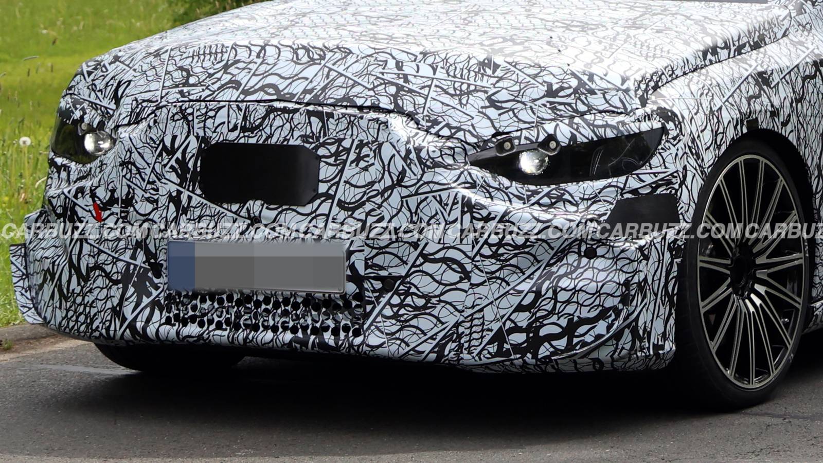Un'auto sportiva elettrica con spoiler e dettagli AMG in prova sulle strade di Nürburgring